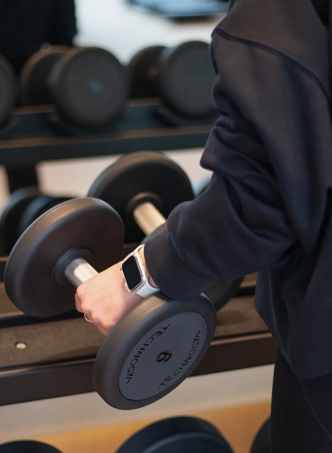 A member lifting a dumbbell from the rack